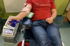 Młody mężczyzna w czerwonym podkoszulku oddaje krew