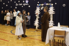 Dzieci odgrywające Maryję i Józefa rozmawiają z chłopcem w długiej, brązowej szacie