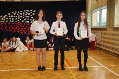 dwie uczennice i jeden uczeń stoją z nagrodami w rękach