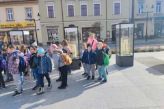 Uczniowie pozują na tle gablot na rynku w Bochni