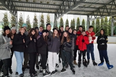 Grupa uczniów pozujących na tafli lodowiska