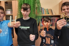 Czterech chłopców, każdy z nich w ręce trzyma kształty liter wykonane długopisem 3D