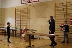 Dwaj chłopcy trzymają linę, na której porusza się kartonowy mikołajek