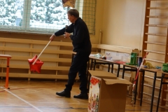 Nauczyciel podbija plastikowym kijem czerwony balon w kształcie gwiazdy