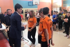 Grupa uczniów w pomarańczowych koszulkach odbiera nagrody
