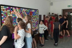 Grupa dzieci przy tablicy świetlnej układa wzory.