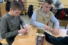 Dwaj chłopcy przy stoliku liczą pieniądze