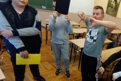 Troje uczniów biorących udział w ćwiczeniu z kolorami przemocy: żółtym, czarnym